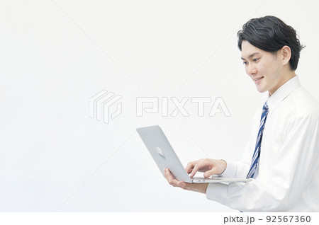 コピースペースがある白バックでノートパソコンを使うビジネスマン コピースペースがある白バックでノートパソコンを使うビジネスマン 92567360
