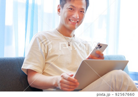 パソコンとスマホを操作する男性 パソコンとスマホを操作する男性 92567660