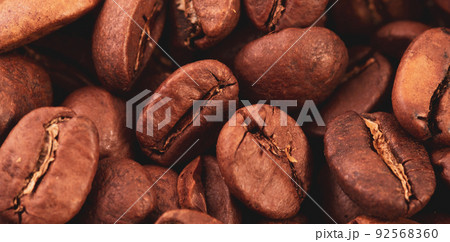 Coffee lover view of roasted coffee beans for background and texture. Dumped roasted coffee beans can be used as background and texture. Photo banner. roasted coffee 92568360