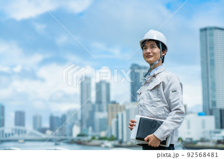 屋外で働くヘルメットを被った若いエンジニア 92568481