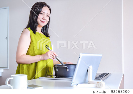 タブレットで動画を見ながら料理をする若い女性 タブレットで動画を見ながら料理をする若い女性 92568500