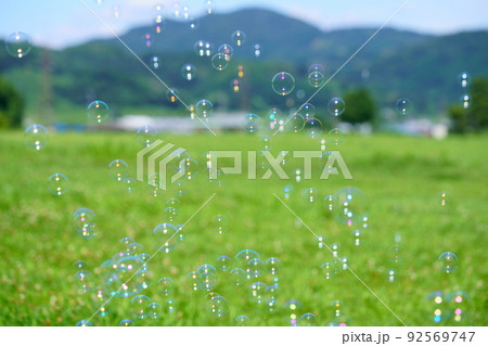 緑の芝でシャボン玉遊び 92569747