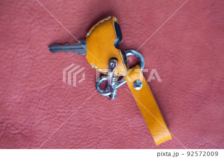 Genuine keychain leather crafts working on red leather background Genuine keychain leather crafts working on red leather background 92572009