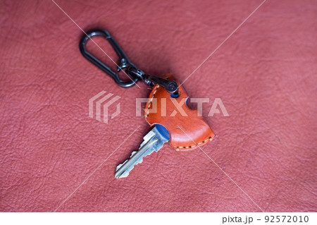 Genuine keychain leather crafts working on red leather background Genuine keychain leather crafts working on red leather background 92572010