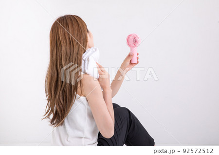 タオルで汗を拭う女性 Woman wiping sweat with a towel タオルで汗を拭う女性 Woman wiping sweat with a towel 92572512