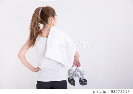 タオルを肩に掛けてスニーカーを持つ女性 sports タオルを肩に掛けてスニーカーを持つ女性 sports 92572517