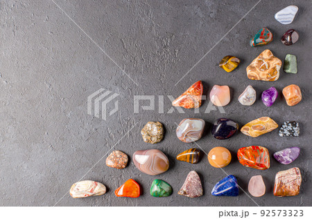 Mineral stones on a black concrete background. The concept of using minerals in astrology and alternative or complementary medicine. Copy space. 92573323