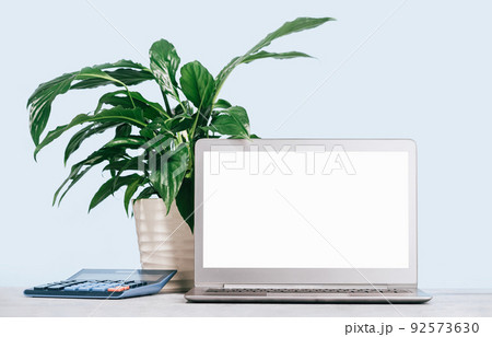 Front view of the laptop with mockup screen on the desk. calculator 92573630