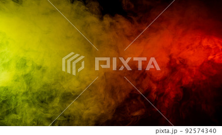 Red-yellow smoke spreads on a black background. Red-yellow smoke spreads on a black background. 92574340