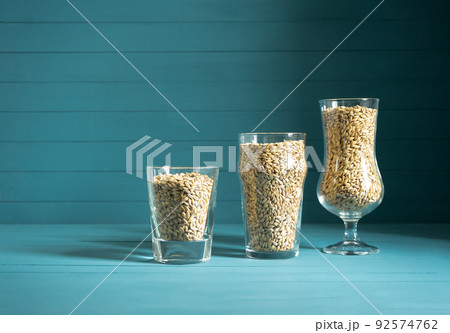 beer glasses with barley malt on black background. Craft beer brewing from grain barley pale malt. Homemade ale or lager from pilsner malt. beer glasses with barley malt on black background. Craft beer brewing from grain barley pale malt. Homemade ale or lager from pilsner malt. 92574762