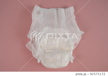 Adult diaper on a pink background. Incontinence problems. Adult diaper on a pink background. Incontinence problems. 92575172