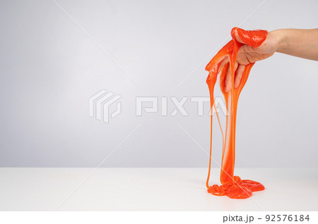Red slime flowing down from a woman's hand on a white background.  92576184