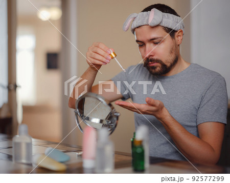 Men's beauty concept. caucAsian guy checking his skin. Men's beauty concept. caucAsian guy checking his skin. 92577299