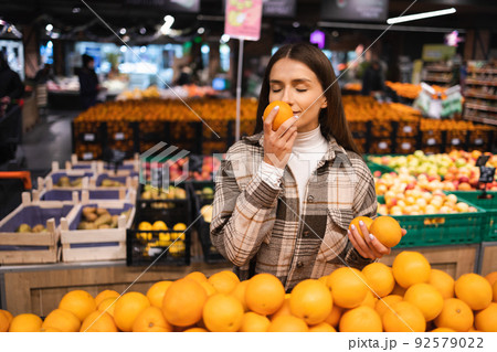 Woman smell orange while shopping in grocery supermarket 92579022