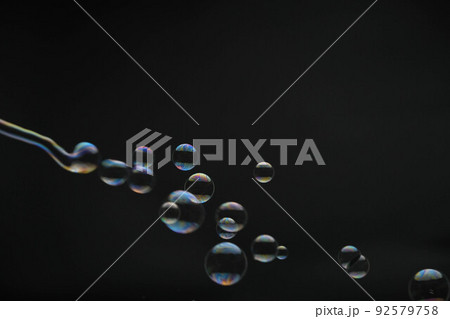 Flying soap bubbles on black background. Abstract soap bubbles with colorful reflections. Soap bubbles in motion background. Flying soap bubbles on black background. Abstract soap bubbles with colorful reflections. Soap bubbles in motion background. 92579758