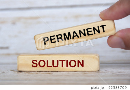 Hand holding wooden blocks with text - Permanent solution. 92583709