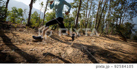 Woman trail runner running at sunrise tropical forest mountain peak Woman trail runner running at sunrise tropical forest mountain peak 92584105