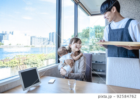 レストランでくつろぐ親子と困るホールスタッフ 92584762