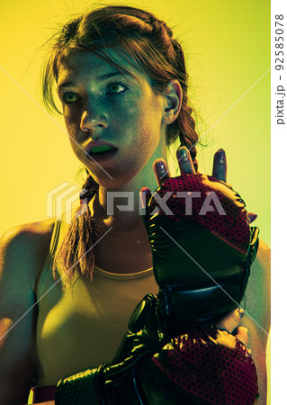 Motiovation for win. Young girl, MMA fighter in sports uniform isolated on yellow background. Concept of sport, competition, action, healthy lifestyle. 92585078