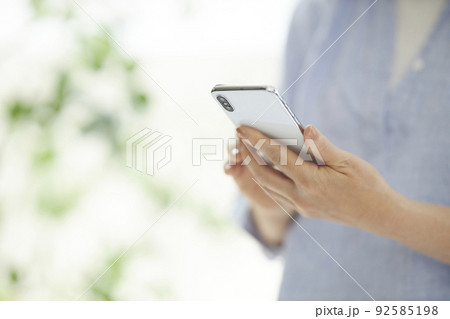 スマホを操作するミドル女性の手元 スマホを操作するミドル女性の手元 92585198