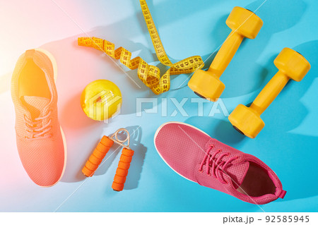 Female sport shoes and equipment top view, copy space. Active lifestyle, body care concept. Sun flare Female sport shoes and equipment top view, copy space. Active lifestyle, body care concept. Sun flare 92585945