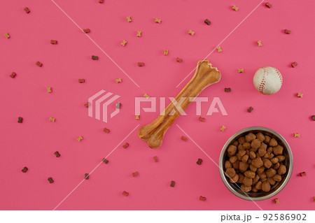 Dog snacks, dog chews, dog bone, ball toy for dog on a pink background with copy space Dog snacks, dog chews, dog bone, ball toy for dog on a pink background with copy space 92586902