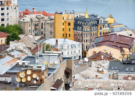 Satellite dishes on the roof of old city houses. 92589208