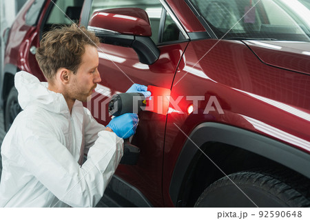 Professional auto painter matches car paint color with lamp and samples 92590648