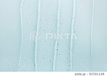 Liquid gel abstract cosmetic blue background. Smear of transparent moisturizing product Liquid gel abstract cosmetic blue background. Smear of transparent moisturizing product 92591198