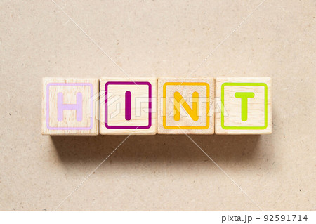 Color letter block in word hint on wood background 92591714
