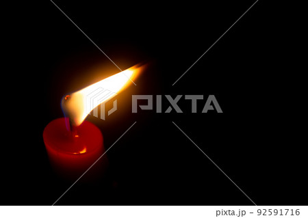 Red candle with yellow flame on black background Red candle with yellow flame on black background 92591716