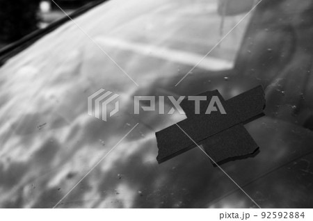 Tape covering a chip on a car windshield. Tape covering a chip on a car windshield. 92592884