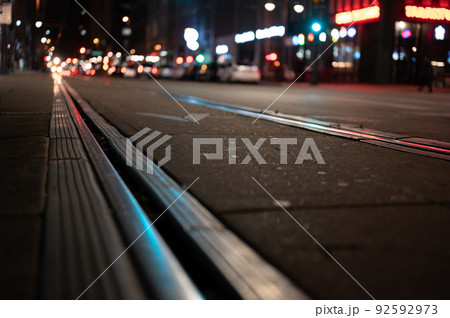 Street level selective focus on trolley rail lines at night in San Diego. Street level selective focus on trolley rail lines at night in San Diego. 92592973