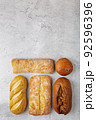 Baking background with various fresh baked whole loaves of bread flat lay on gray surface with copy space. 92596396