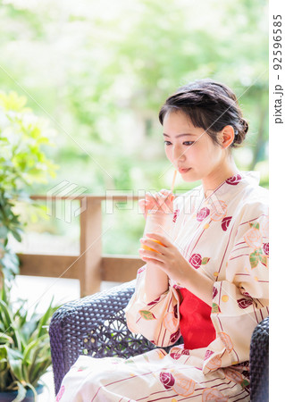 浴衣姿でジュースを飲む若い女性 92596585