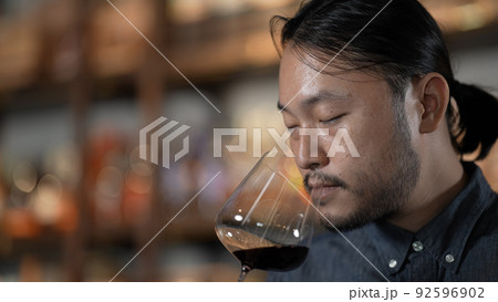 Night club concept of 4k Resolution. Asian man tasting wine in a restaurant. A group of specialized clubs that sell alcoholic beverages. Night club concept of 4k Resolution. Asian man tasting wine in a restaurant. A group of specialized clubs that sell alcoholic beverages. 92596902