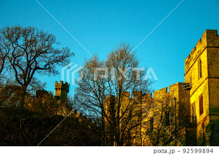 Ancient European medieval architectural building castle in golden autumn light with the blue sky background during autumn Ancient European medieval architectural building castle in golden autumn light with the blue sky background during autumn 92599894