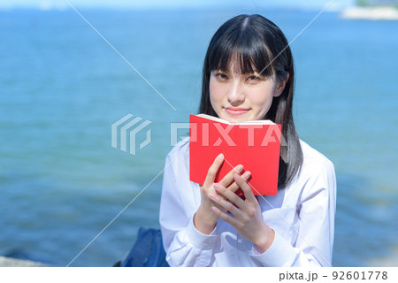 綺麗な海辺の防波堤に座って手帳を見る女子高校生 スケジュール 予定 綺麗な海辺の防波堤に座って手帳を見る女子高校生 スケジュール 予定 92601778