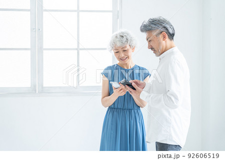 スマホを見るシニア夫婦 92606519
