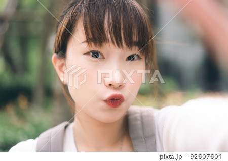 Portrait of young cute asian teenager student woman take a selfie photo by mobile phone 92607604