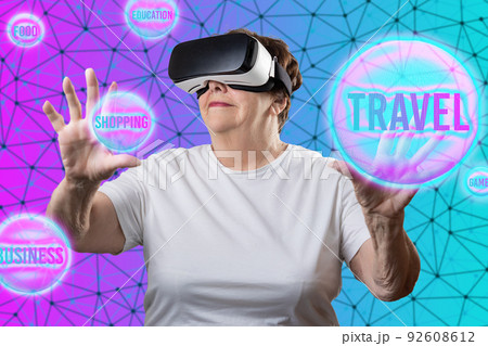 Metaverse. Caucasian smiling elder woman in VR glasses choosing digital spheres with interests. Neon purple and turquoise background with grid. Concept of retiree, virtual reality and cyberspace 92608612