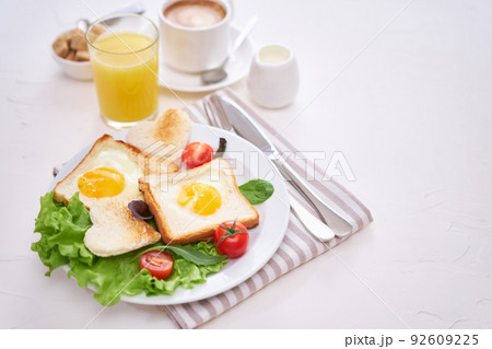 Fried Egg on Toast Bread and cup of fresh hot coffee on light grey background Fried Egg on Toast Bread and cup of fresh hot coffee on light grey background 92609225