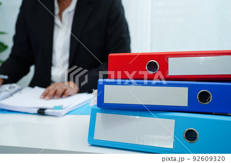 Stack of binder file folder on table in business modern office..on wooden desk in large modern office Stack of binder file folder on table in business modern office..on wooden desk in large modern office 92609320