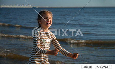 laughing girl of 4 years in dress happy on beach summer, selective focus laughing girl of 4 years in dress happy on beach summer, selective focus 92609811