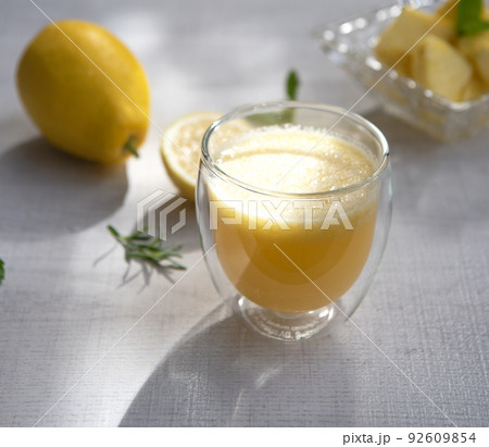 A glass of pineapple smoothie on wooden background with rays of the sun. Helthy food. 92609854