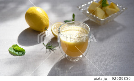 A glass of pineapple smoothie on wooden background with rays of the sun. Helthy food. 92609856