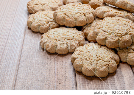 a large stack of gluten free oatmeal cookies on a cutting board. 92610798