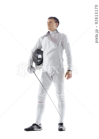 Portrait of professional male fencer in fencing costume and mask holding smallsword isolated on white background. Sport, emotions, energy, skills 92613170