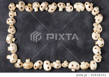 Frame of raw champignon mushrooms in the form of skulls. Edible Halloween Concept Frame of raw champignon mushrooms in the form of skulls. Edible Halloween Concept 92616142