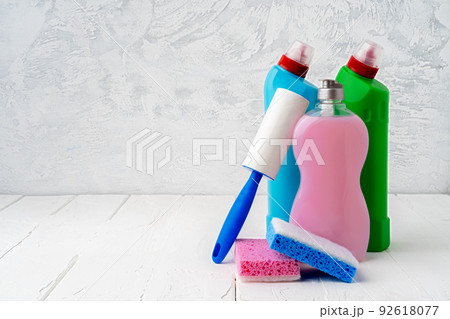 Household cleaning detergents on wooden table against gray background Household cleaning detergents on wooden table against gray background 92618077